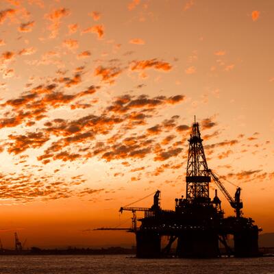 An offshore oil rig at sunset