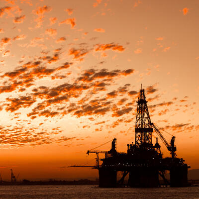 An oil rig shillouted in the sunset