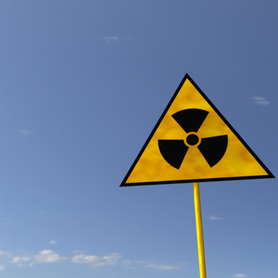 The radiaton symbol on a road sign framed against a blue sky