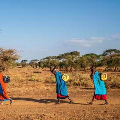 A group of Kenyan women carry water on their backs 