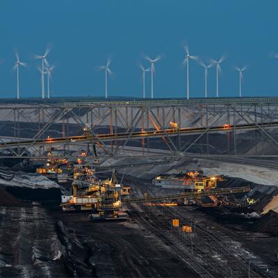 A line of windmills overlooks a coal mine