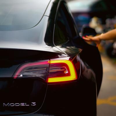 A black Tesla Model 3 viewed from behind