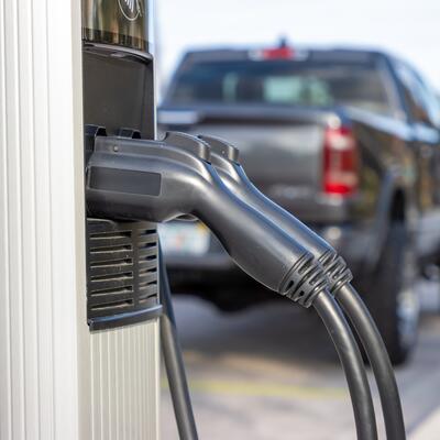 An electric vehicle charger with a pickup truck in the background