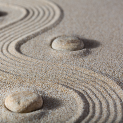small stones and wavy lines drawn into sand