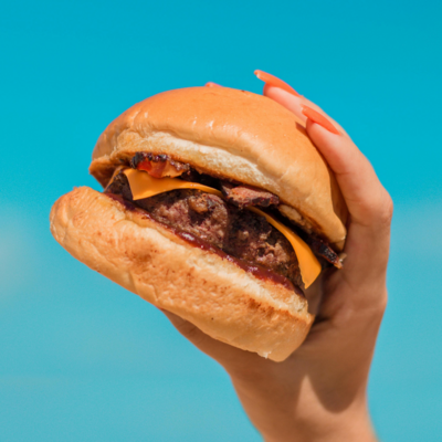 hand holding up cheeseburger
