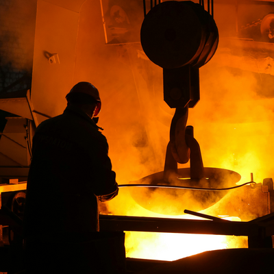 Man in helmet standing near steel melting pool